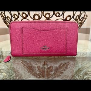 Coach zip wallet in fuchsia pink.